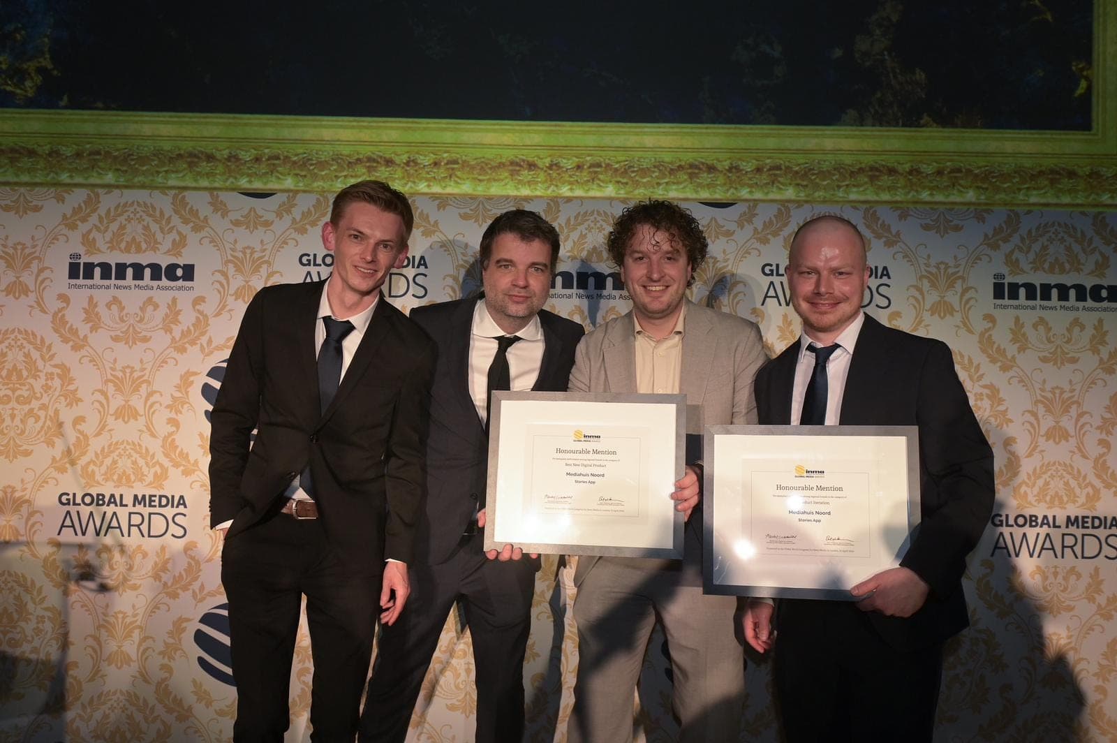 Het app-team in pak voor de wand van de INMA Global Media Awards, met twee ingelijste oorkondes. Sebastiaan is de derde van links.